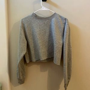 a grey cropped long sleeved sweater